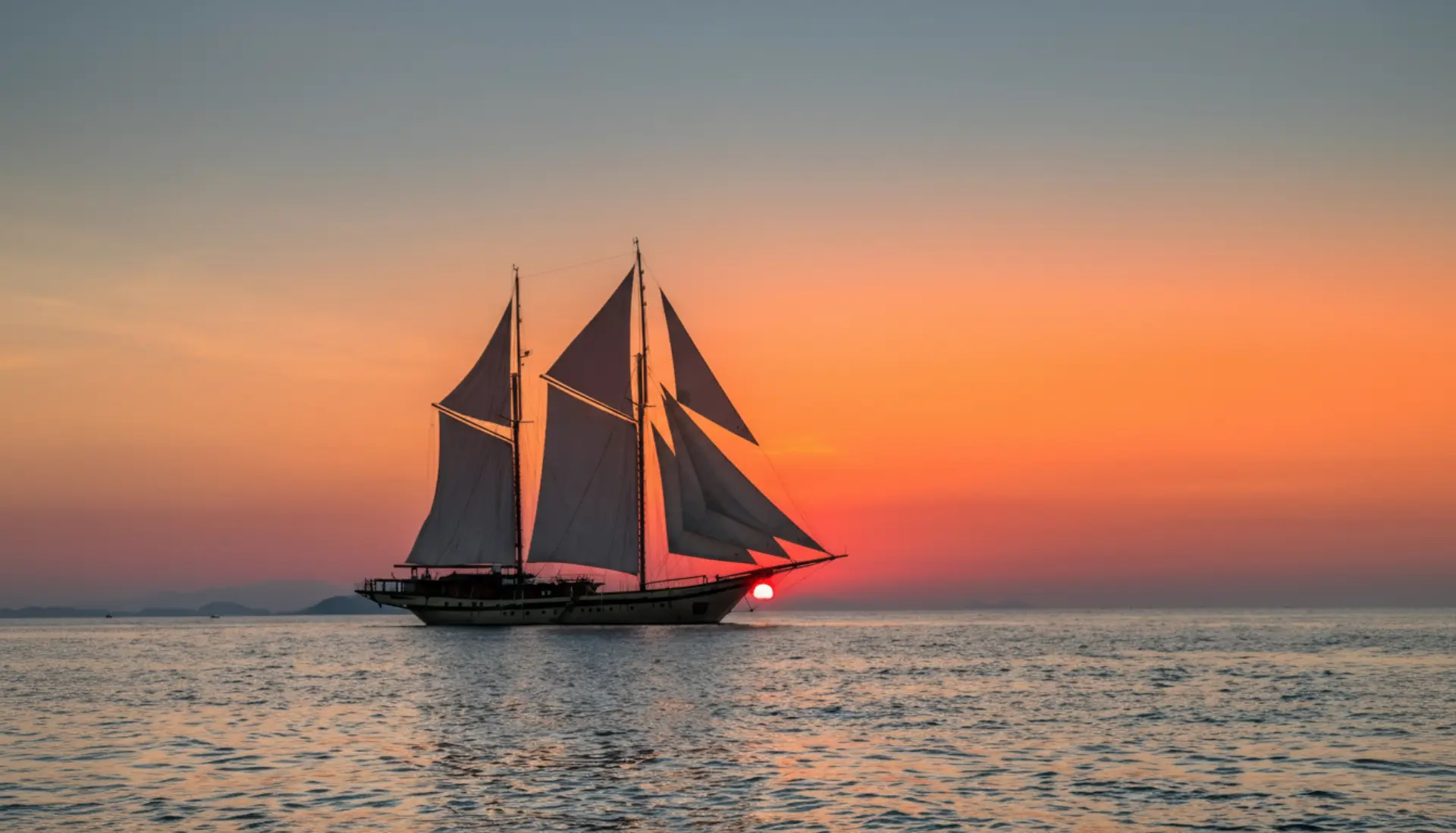 Luxury phinisi sailing yacht at sunset in Indonesian waters Luxury phinisi sailing yacht at sunset in Indonesian waters